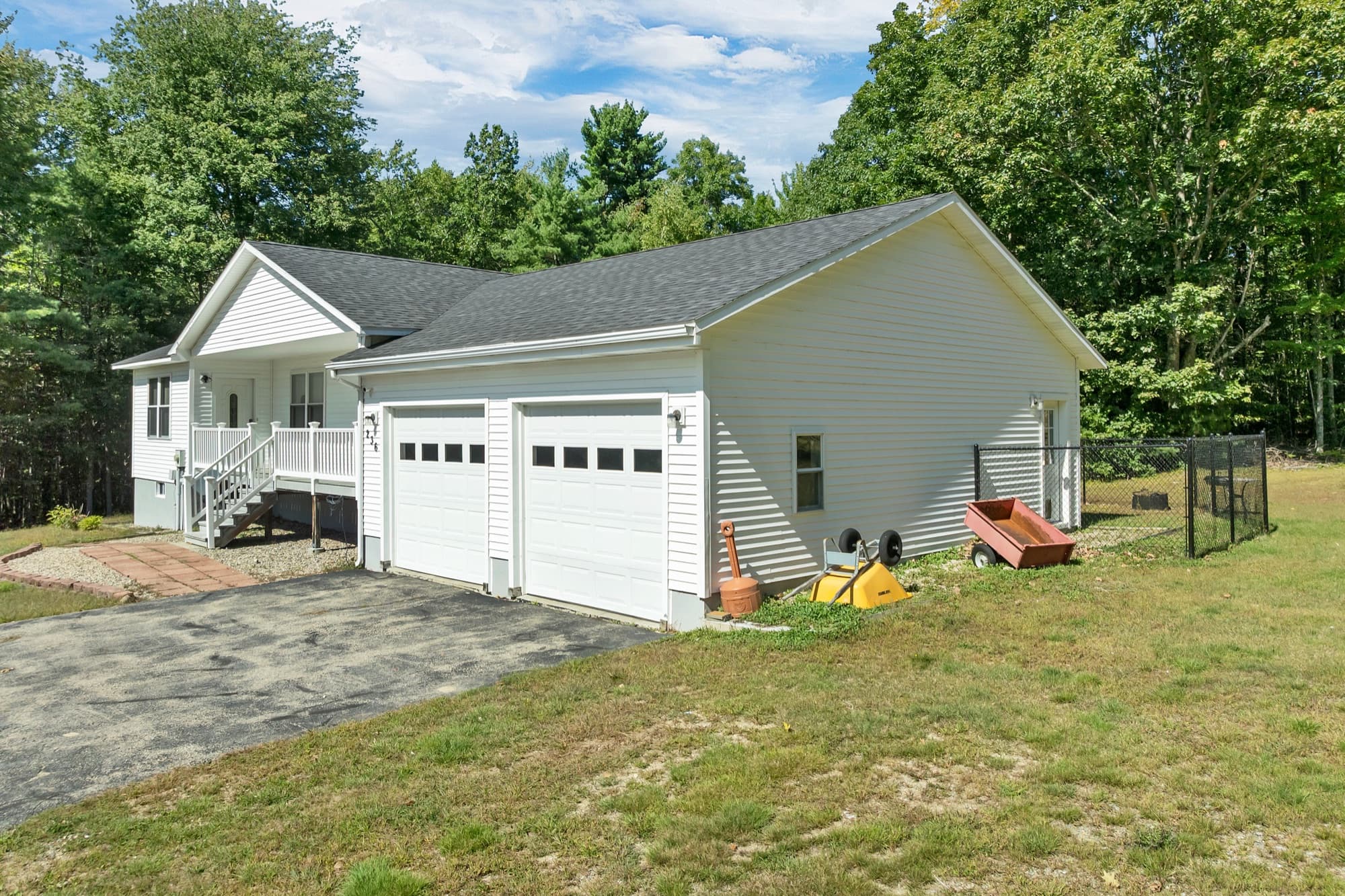 The attached 2-car garage with 2 white doors and the paved driveway